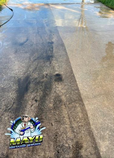 Concrete mid-wash, the clean stripe beside the dirty slab