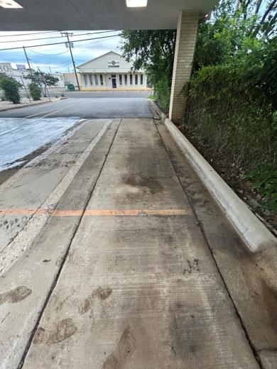 Covered drive at a business, from the far end, mid-wash