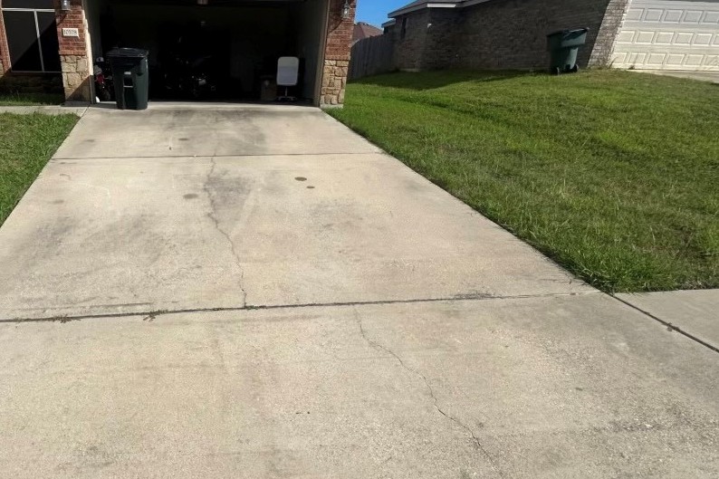 A concrete driveway dark with stains